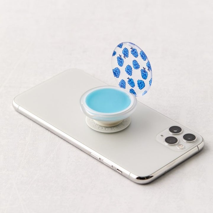 The top of the PopSocket phone grip flips up to reveal the lip balm