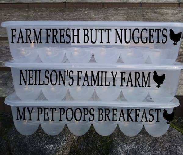 Three containers stacked on top of each other with grooves to fit eggs. They have decals that say "farm fresh butt nuggets," "neilson's family farm," and "my pet poops breakfast" 