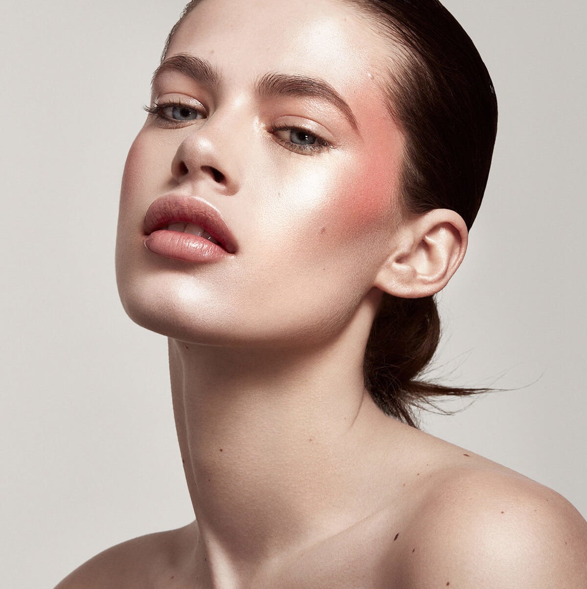 A model wearing the Shimmer Skinstick as blush