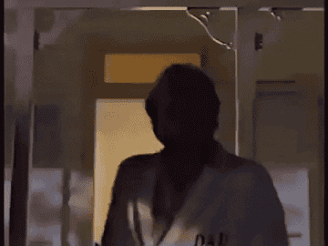Gif of man smiling and wearing bathrobe that says DAD on it  