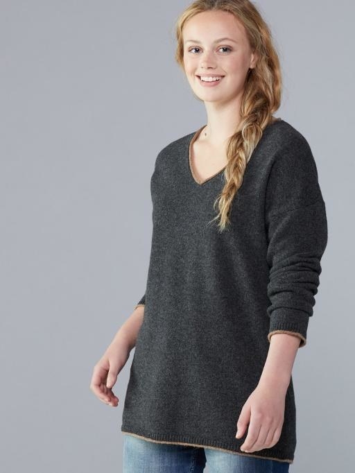 A grey V-neck sweater paired with blue jeans