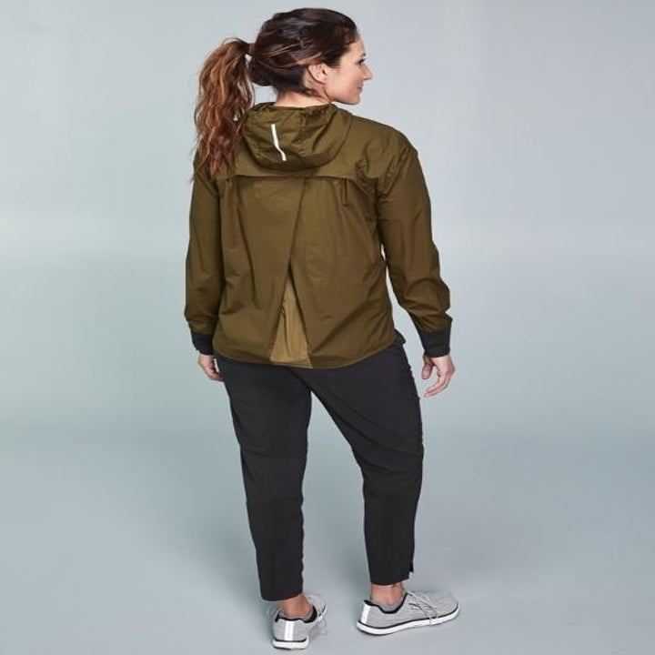 Back view of black active pants paired with brown windbreaker