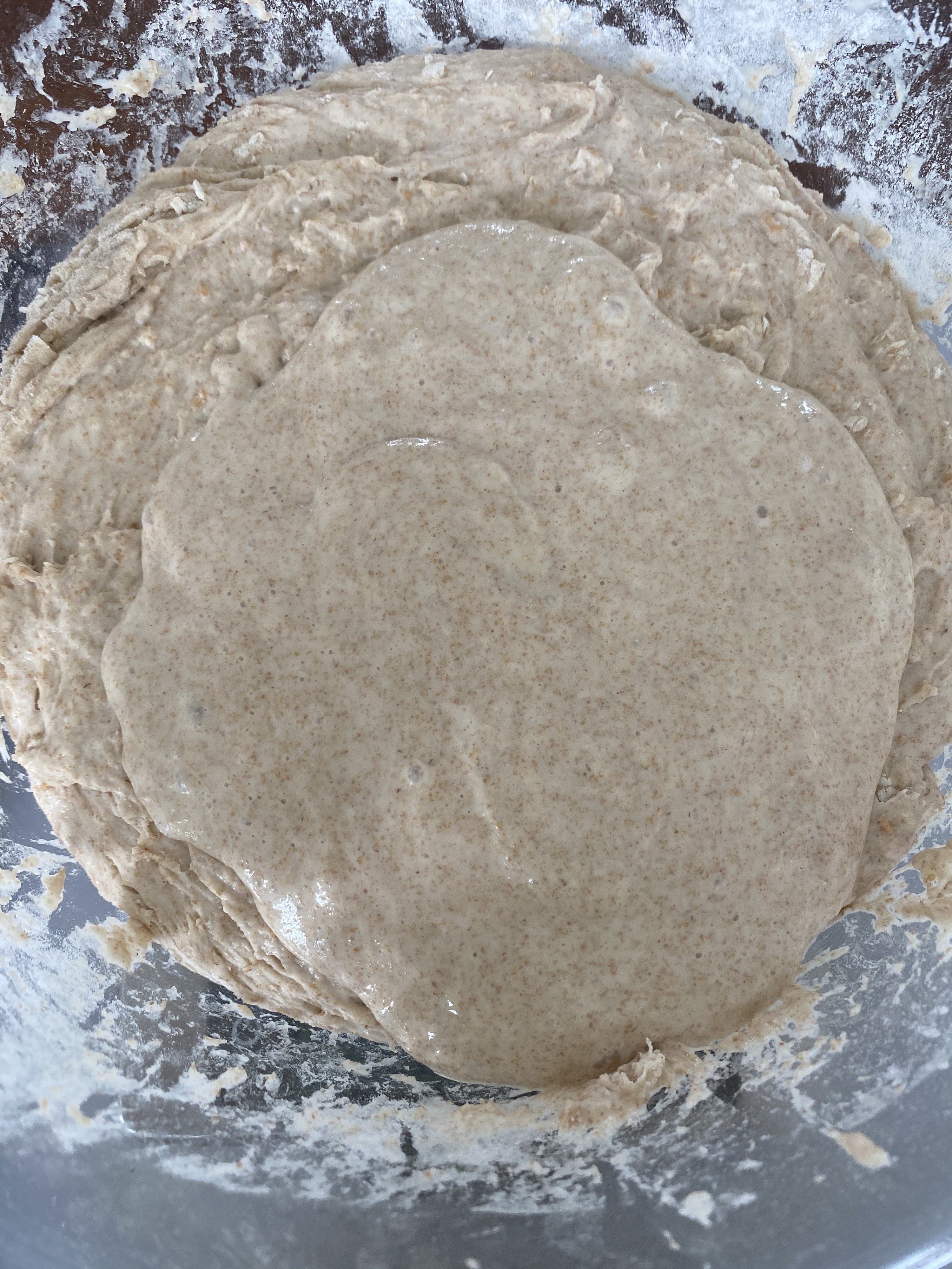 A bowl containing a portion of sourdough starter and the autolyse (flour and water mixture).