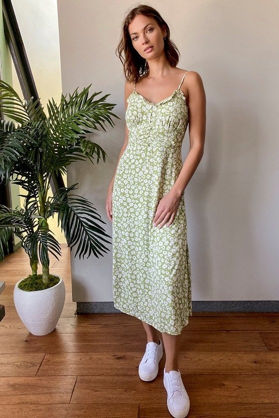 A model wearing the light green and white floral midi dress with small buttons down the chest