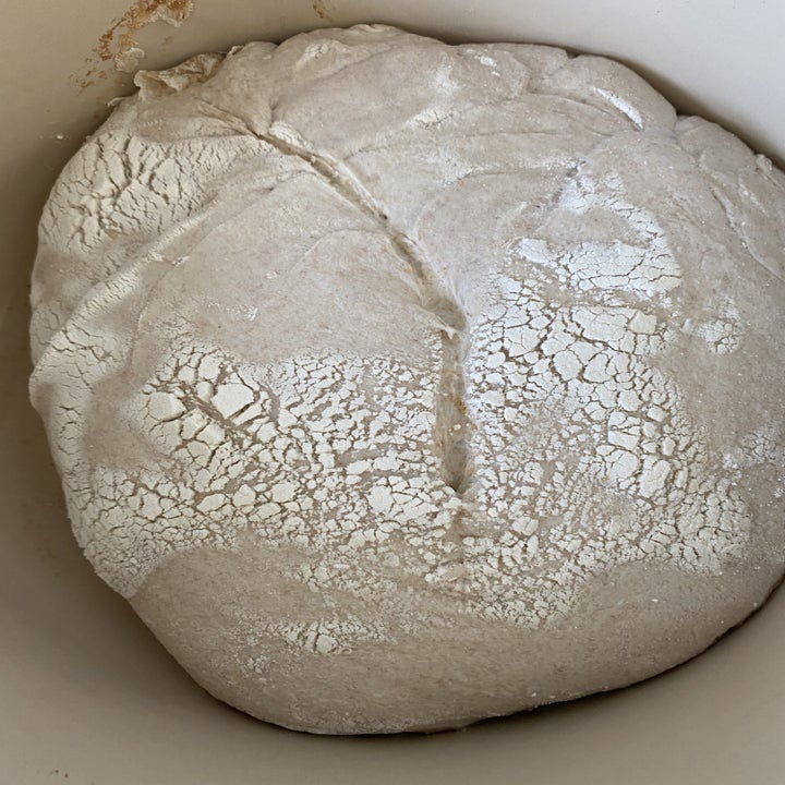 The uncooked loaf of bread in a Dutch oven.