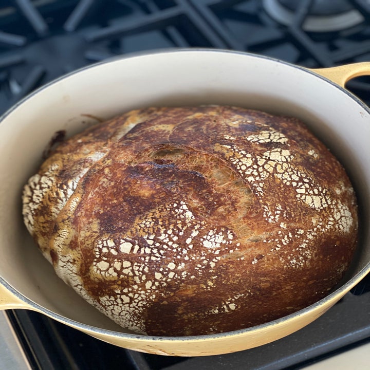 A freshly baked loaf of sourdough bread, just removed from the oven.