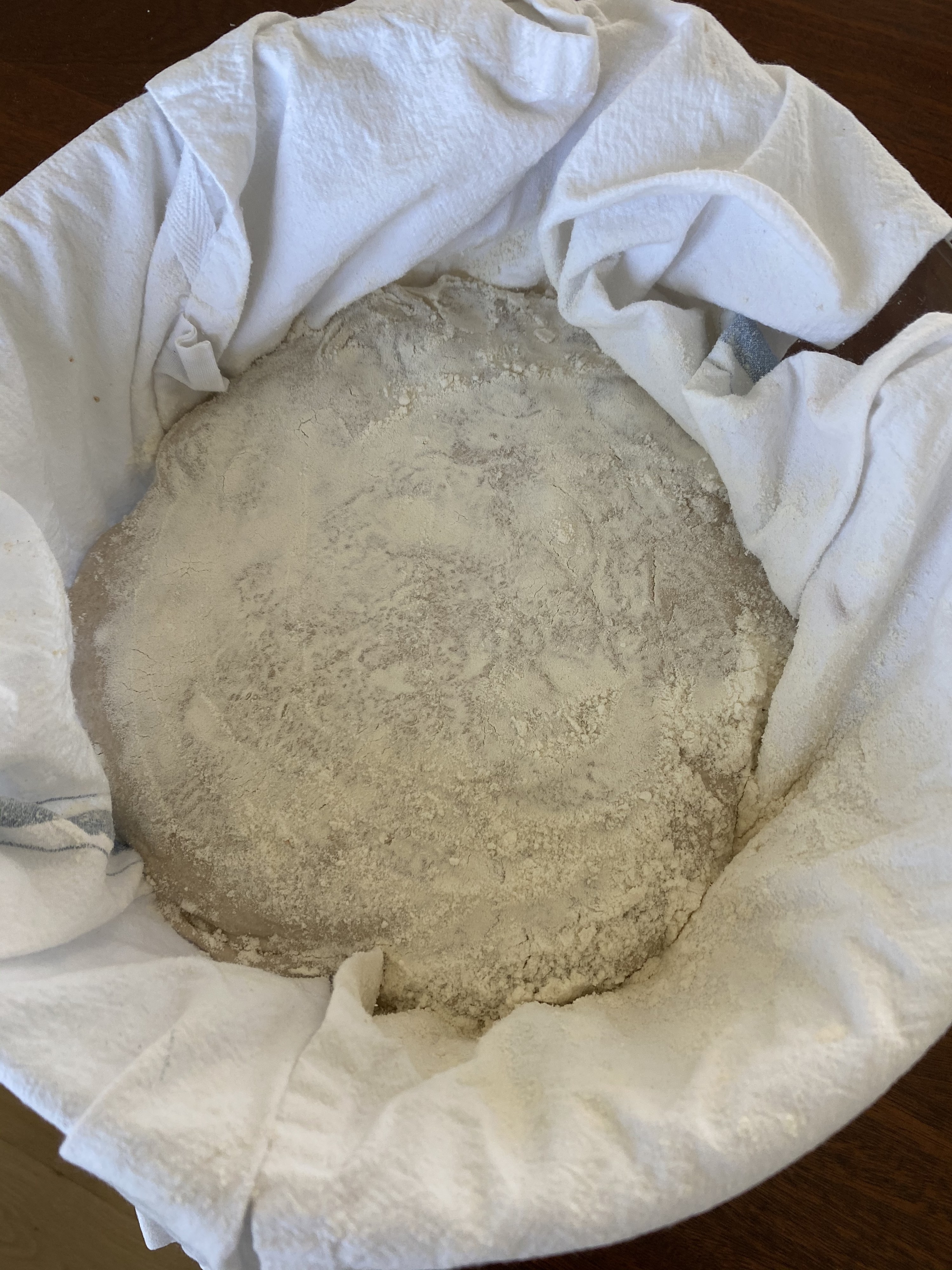 Dough dusted with flour resting at room temperature in a bowl.