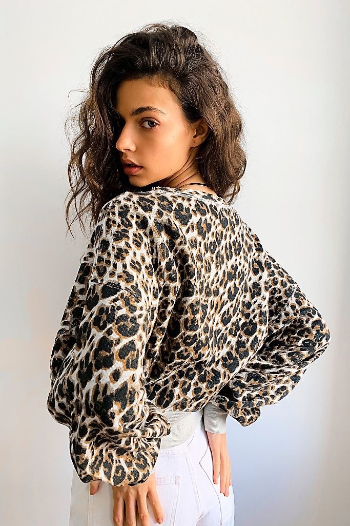 A model wearing the leopard-print sweatshirt to show its slouchy shape 