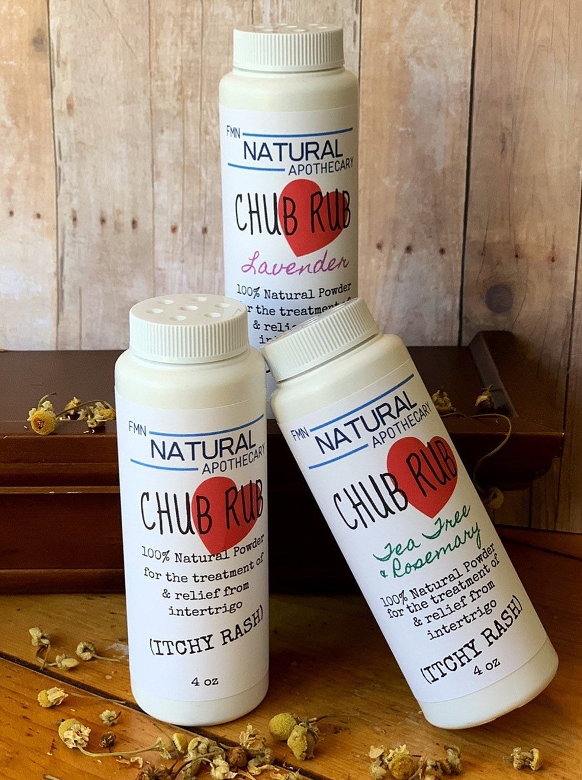 three bottles of the chub rub product arranged on a wood shelf. lid of product has shaker design
