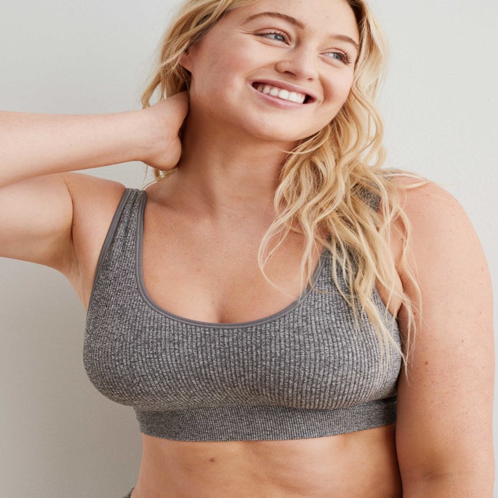 model in grey ribbed bralette that's full coverage, scoop necked and has about one inch straps