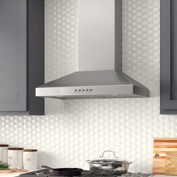 kitchen scene with part of stove visible and white tile backsplash. Main focus is sleek contemporary silver range hood with buttons on the front
