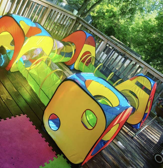 an outdoor tunnel system for kids featuring a bunch of primary colors