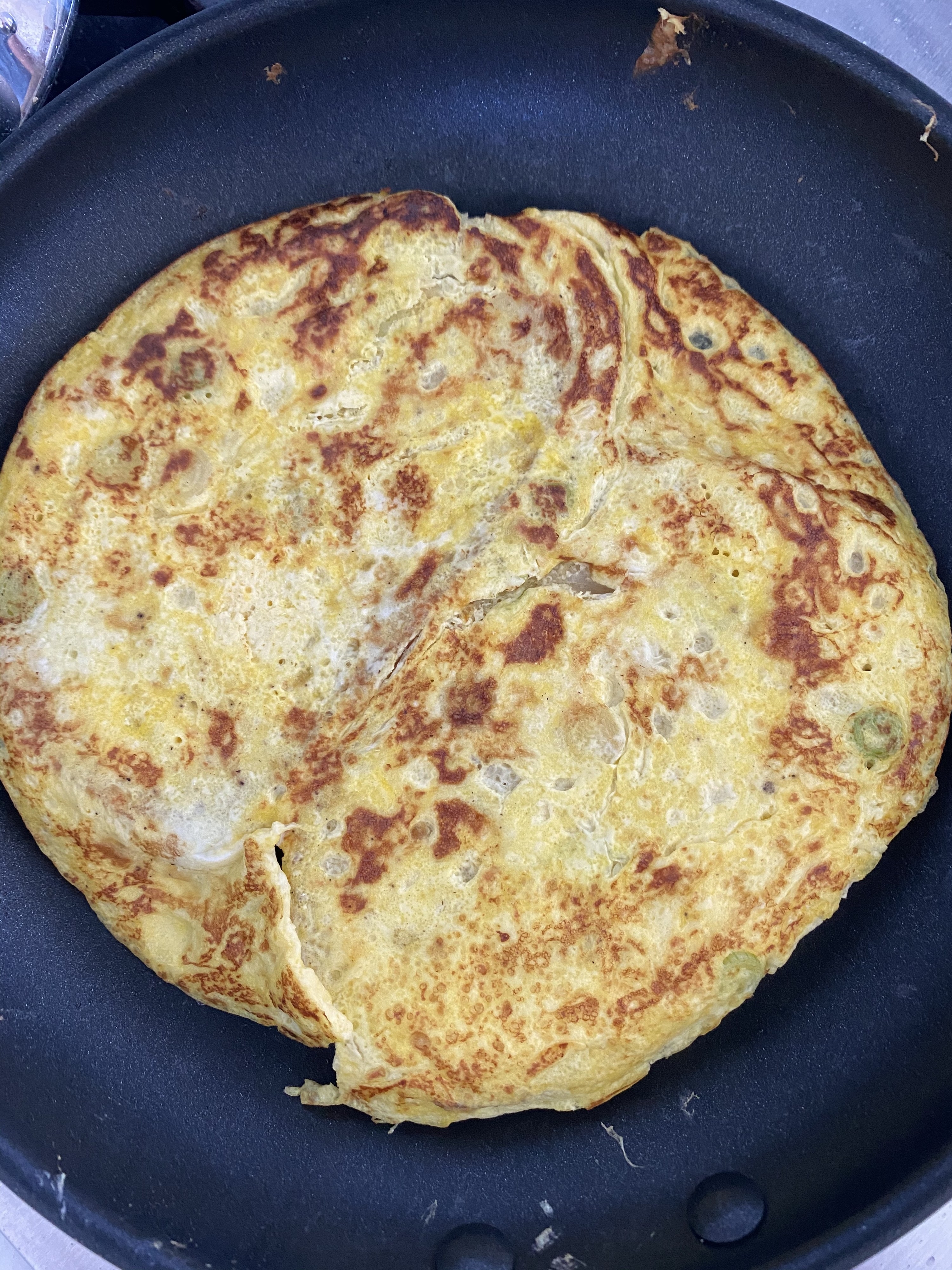 The &quot;omelet,&quot; just flipped in a skillet.