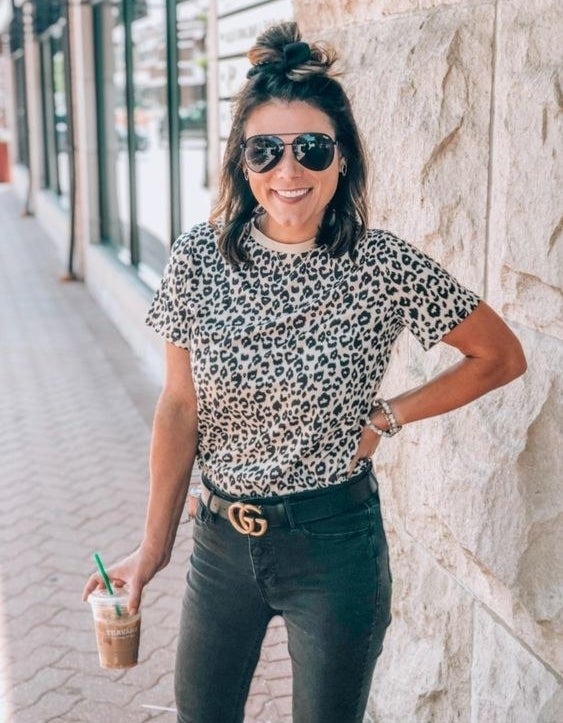 A reviewer wearing the light tan leopard-print T-shirt 