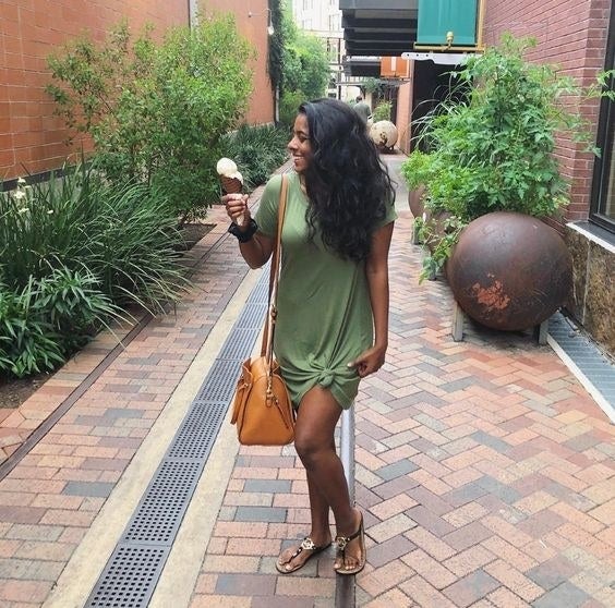 A reviewer wearing the T-shirt dress in olive green and styled with an optional knot