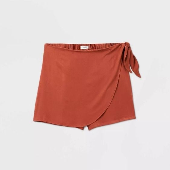 A flat lay of the skort in burnt orange with a wrap tie 