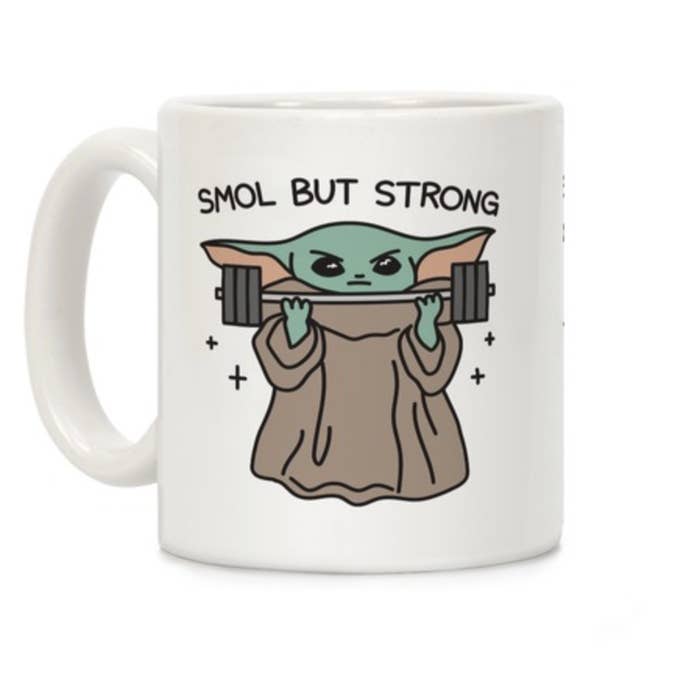 A white mug that says "smol but strong" and artwork featuring Baby Yoda carrying a dumbbell