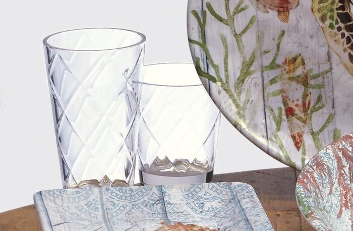 A water glass and a juice glass of varying sizes positioned next to each other on a table