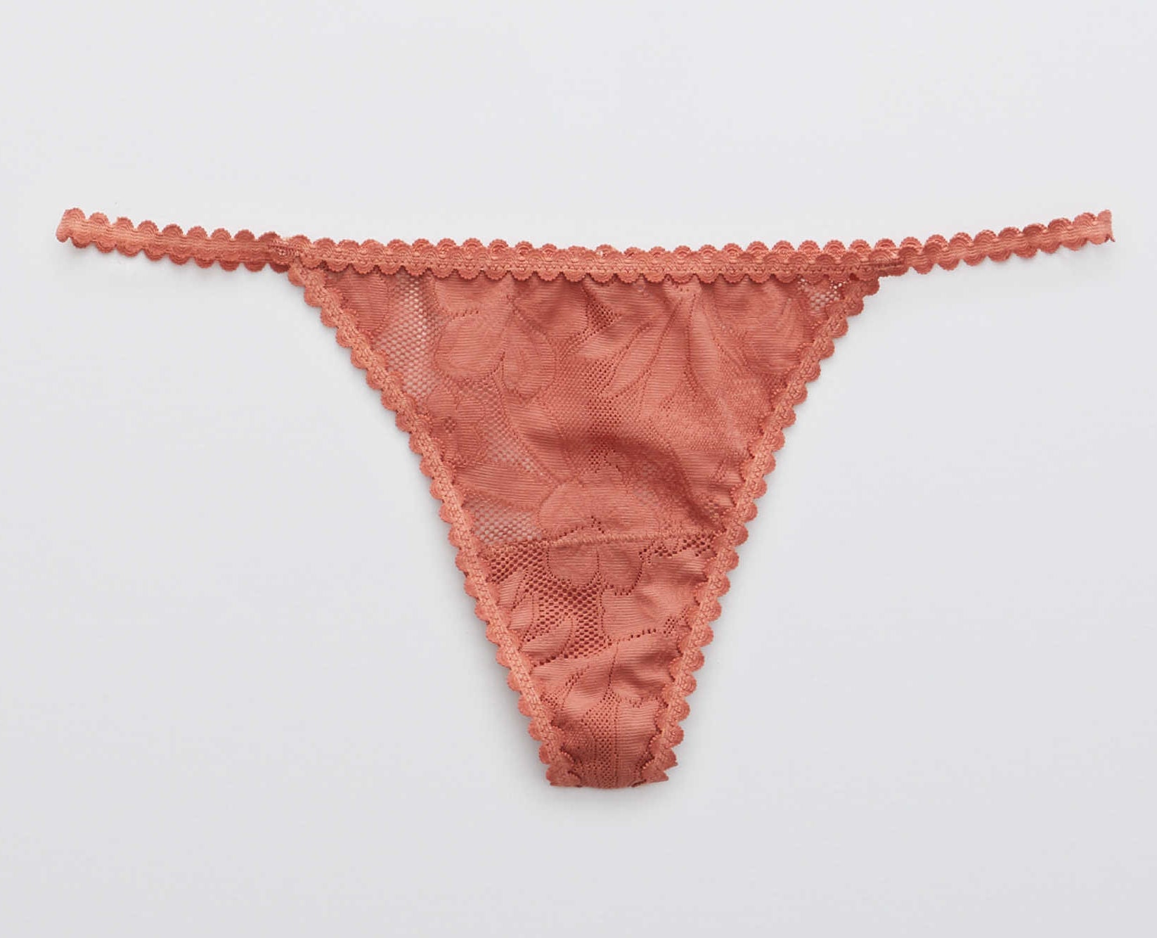a terracotta colored thong made of floral lace with a sting back and sides