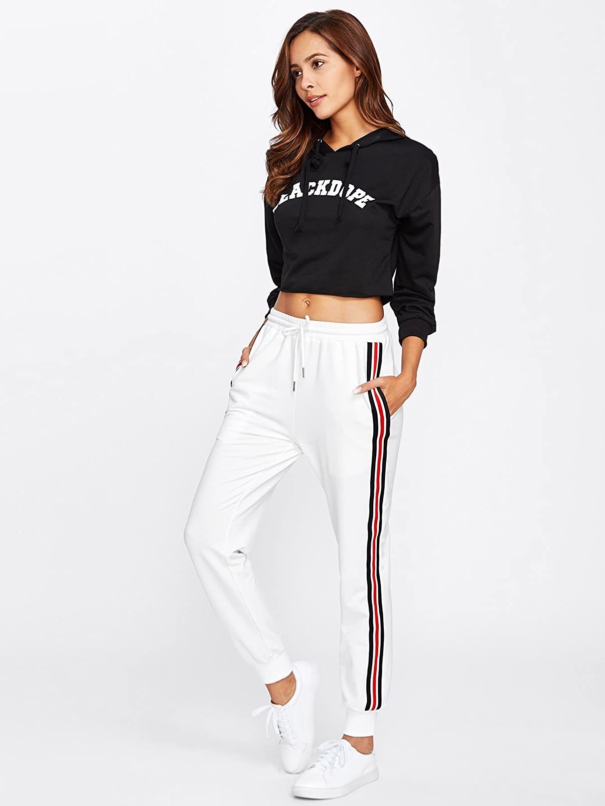 A model wearing the sweatpants in white with red and black side stripes