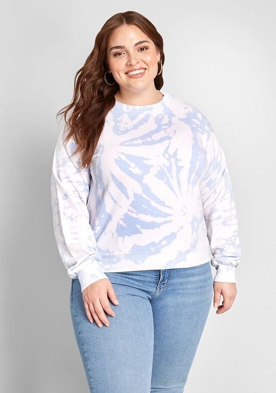 A model wearing the white, light blue, and pink tie-dye crewneck sweatshirt 