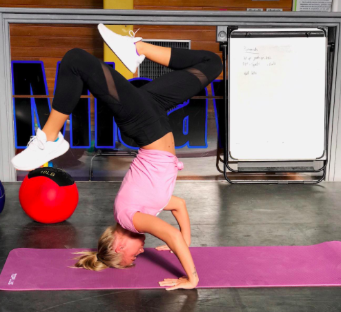 A woman does a headstand on the TOPLUS Yoga mat