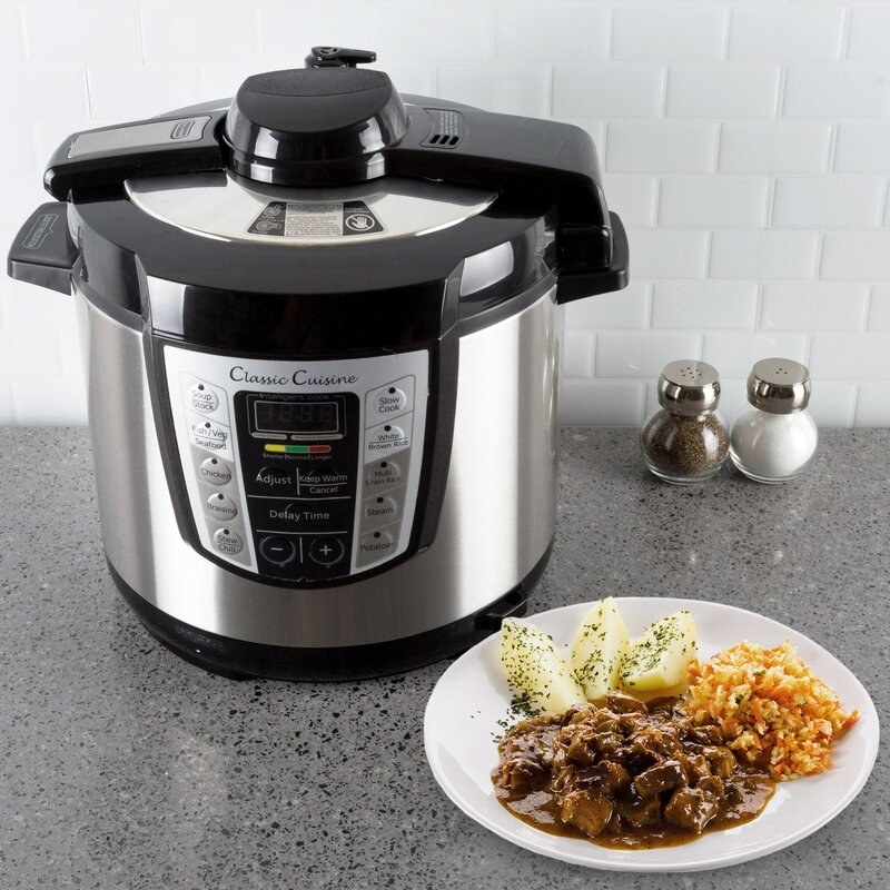 The multicooker on a kitchen counter next to a meal prepared in it 