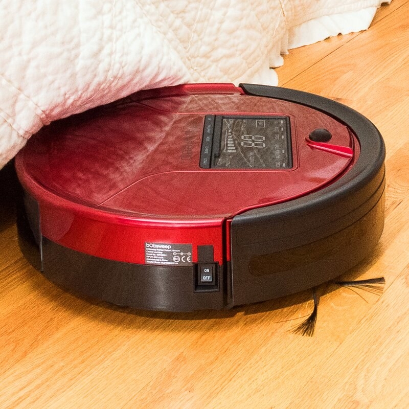 The disc-shaped robot cleaner working on a hardwood floor