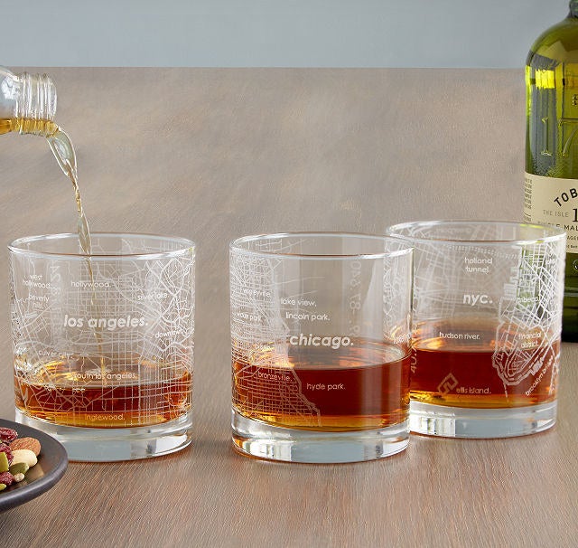 Three whiskey-size glasses etched with maps of LA, Chicago, and NYC