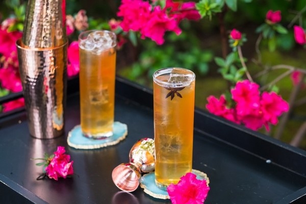 Two golden cocktails with star anise garnish