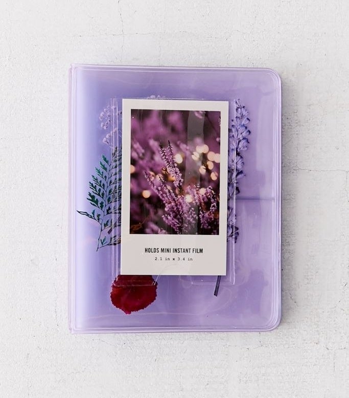 a purple transparent photobook with dried flowers encased inside 