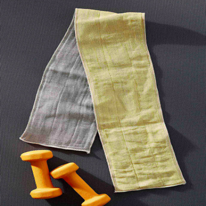 The fitness towel on a plain background next to some handheld weights