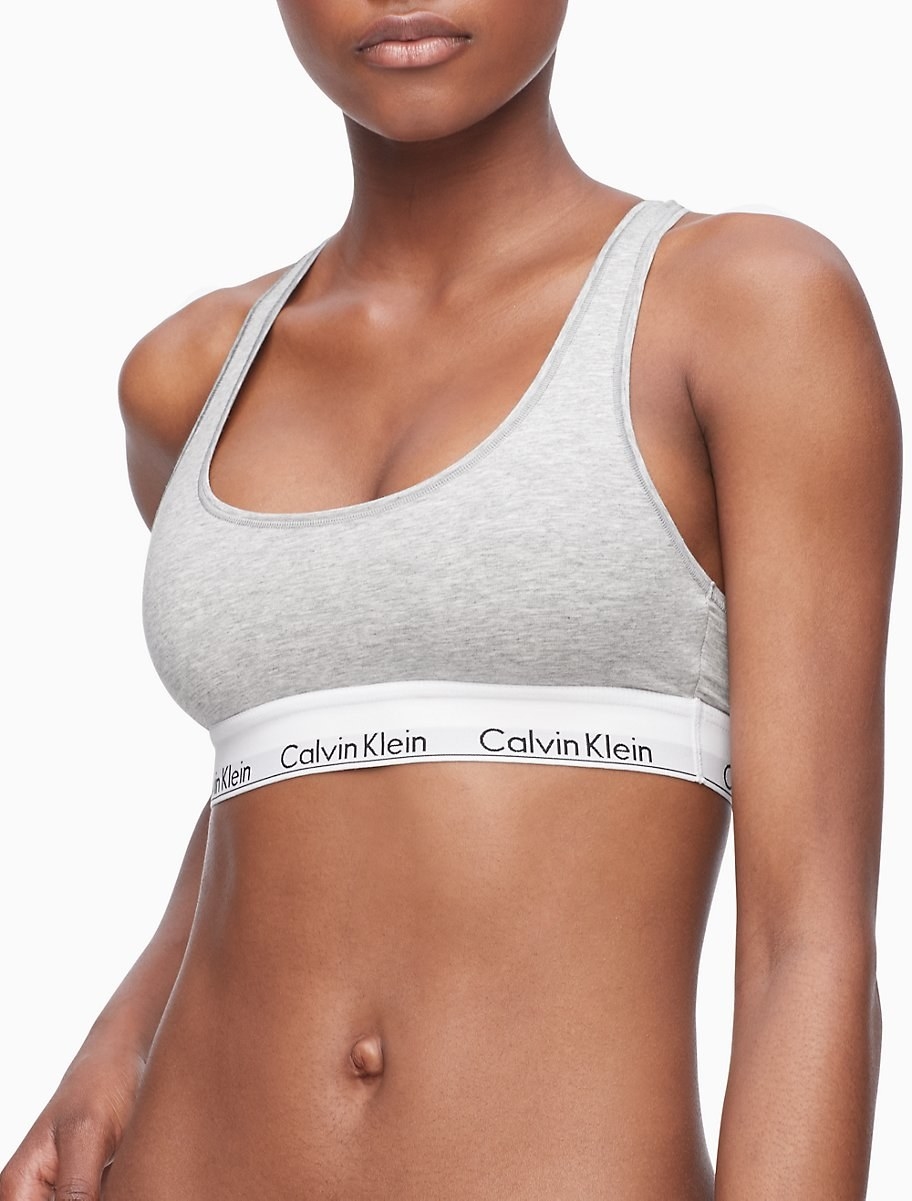 A model wearing a cotton bralette with a band that says Calvin Klein