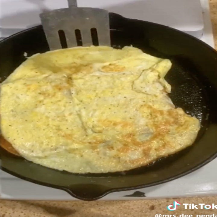 Omelet being flipped in a skillet.