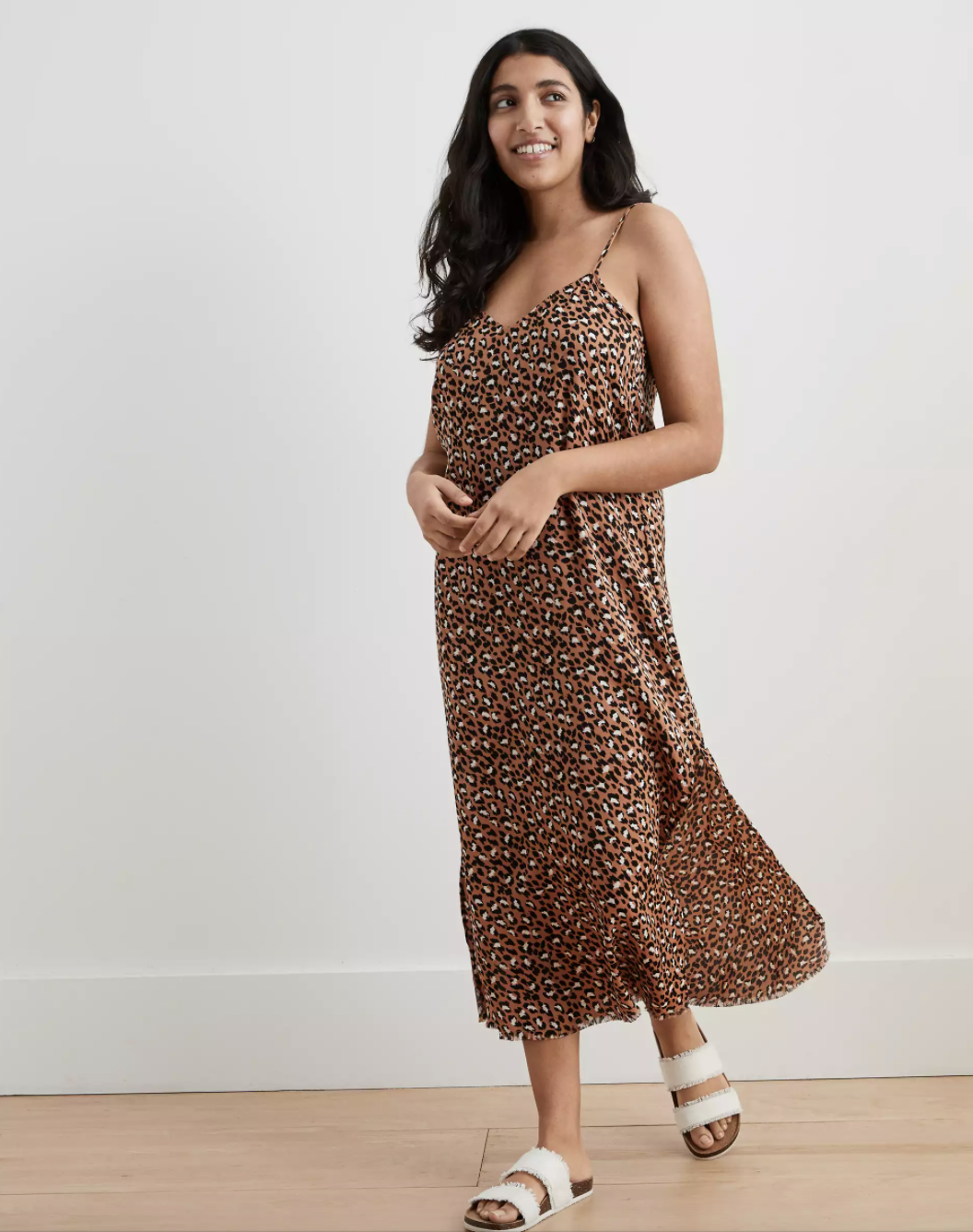 A model wearing the leopard print slip dress with tan slides 