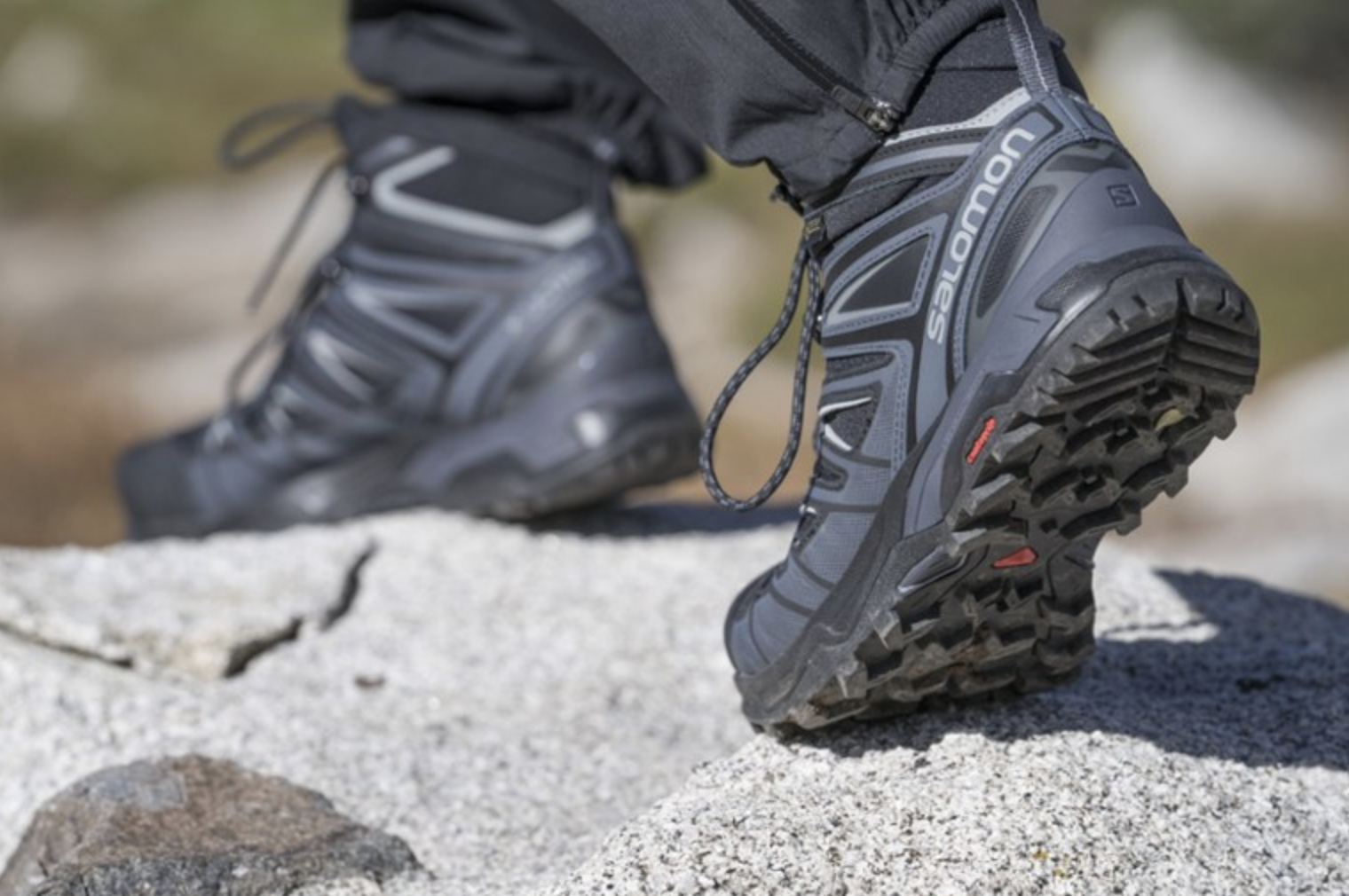 A model wears a pair of Salomon X Ultra 3 Mid GTX Hiking Boots outside