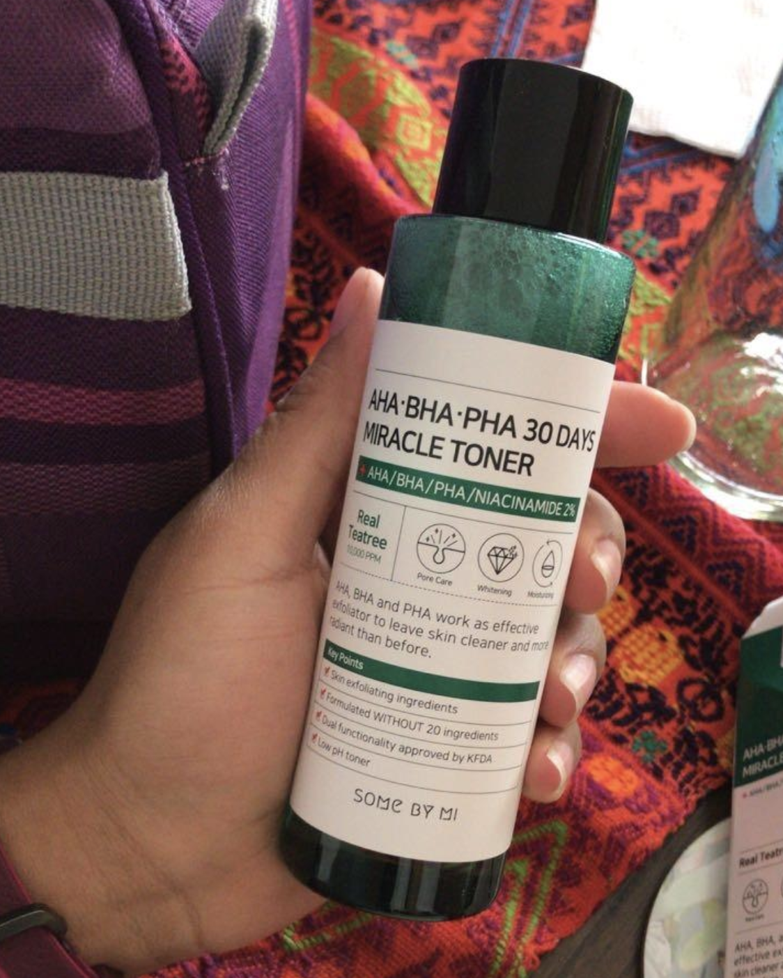 A reviewer&#x27;s hand holding the bottle of toner