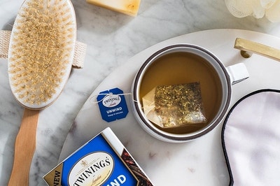 a box of twining's unwind tea next to a mug of freshly brewed tea