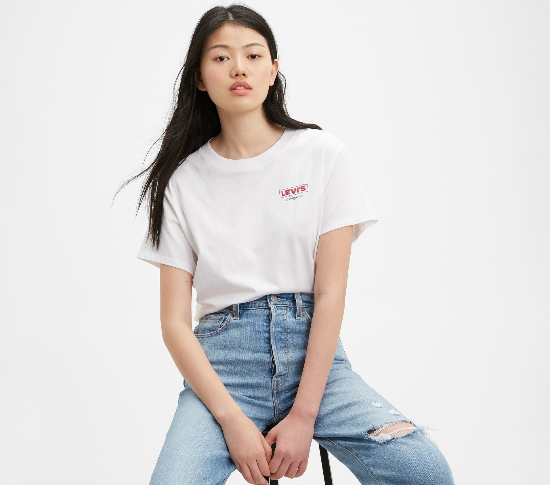 A model wearing the white roomy T-shirt with the Levi's logo on the chest