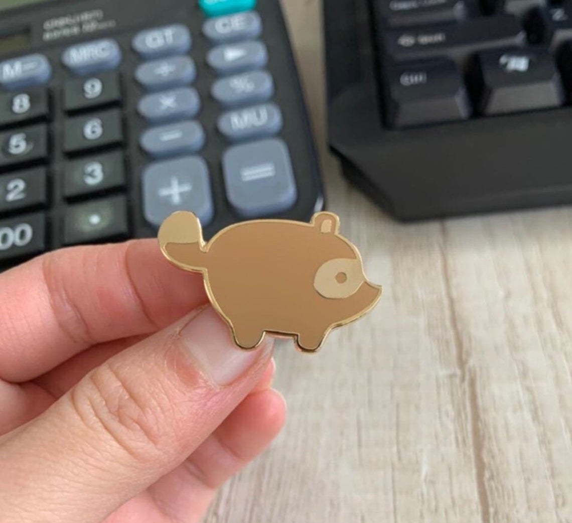 a gold pin that looks like the nook symbol in animal crossing new horizons 