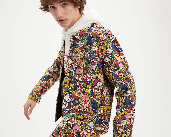 a model wears a jacket covered in nintendo characters