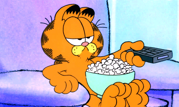 Garfield flicking the remote and sitting in an armchair.