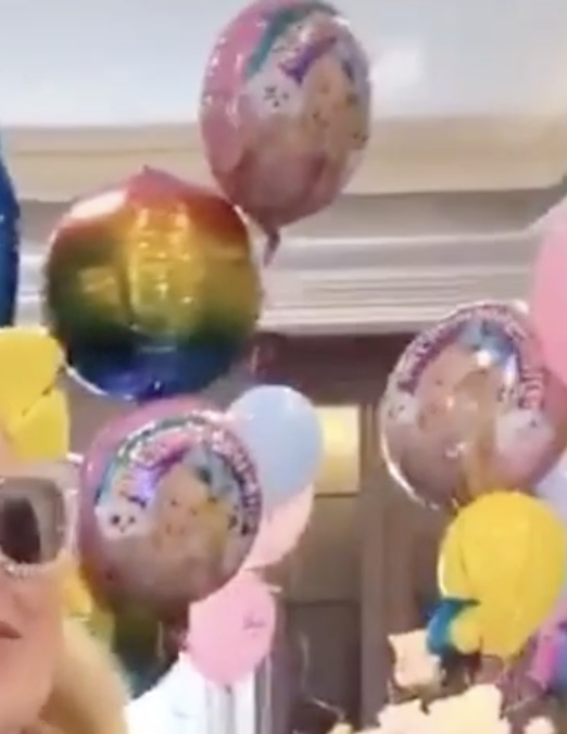 JoJo shows off balloons with her face on.