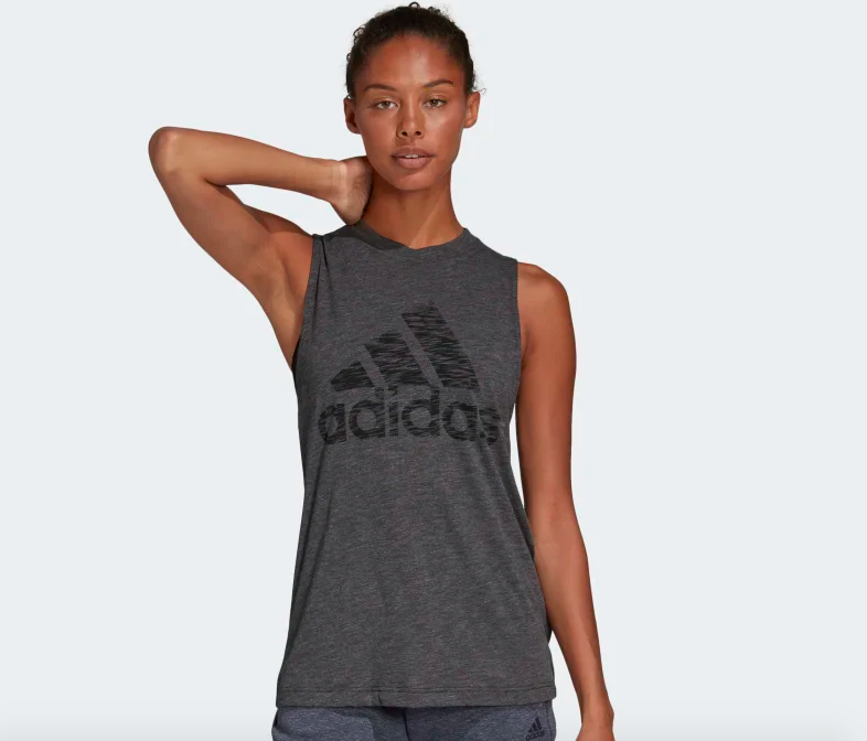 Model wearing gray tank with Adidas logo large across the center chest 