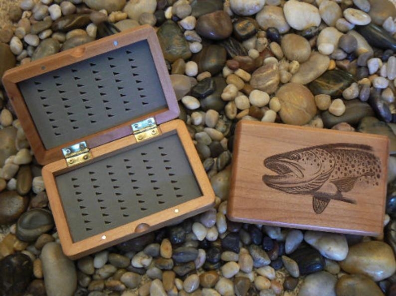 open fly fishing case on a bed of rocks