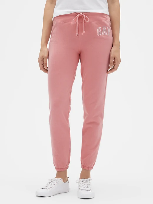 a woman wearing cuffed pink sweatpants that say GAP