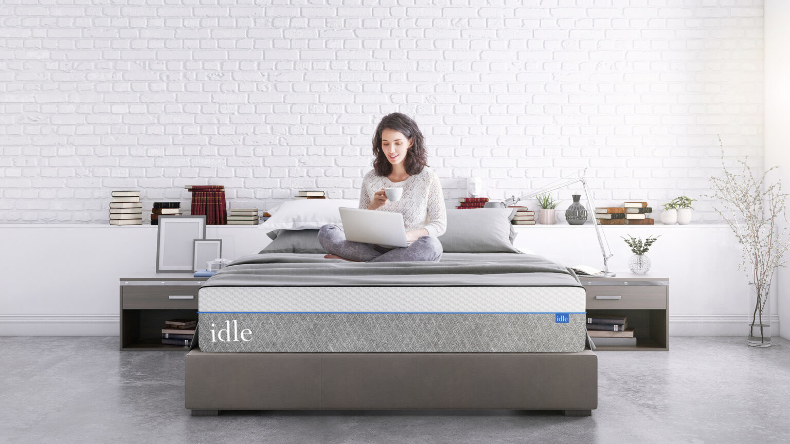 Woman working on her computer sitting atop a thick foam mattress