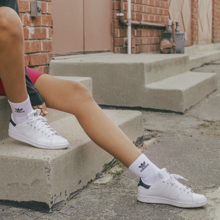 Model wearing Adidas originals Stan Smith sneakers with tube socks