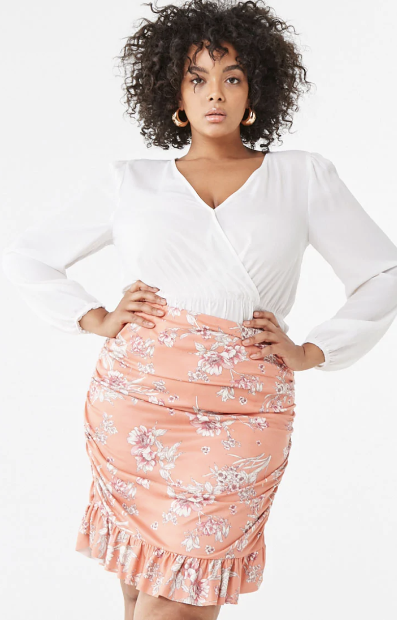 A person wearing a ruffled, knee-length, formfitting high-waisted skirt with flower detailing 