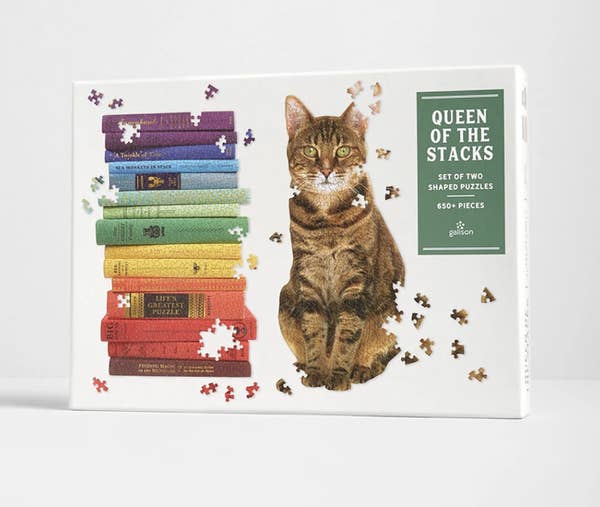 A puzzle box showing two puzzles, one that's a stack of books and the other a cat sitting down 